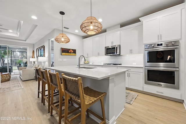 kitchen featuring a sink, visible vents, appliances with stainless steel finishes, and light wood-style flooring