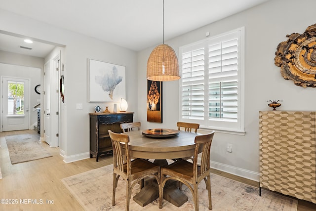 dining space with visible vents, baseboards, and light wood-style floors