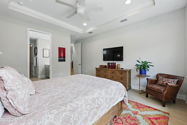 bedroom featuring visible vents, baseboards, a tray ceiling, recessed lighting, and wood finished floors