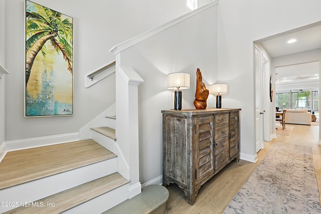 staircase with recessed lighting, baseboards, and wood finished floors