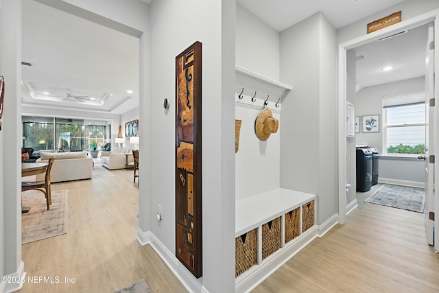 mudroom with ceiling fan, baseboards, light wood-type flooring, and a tray ceiling