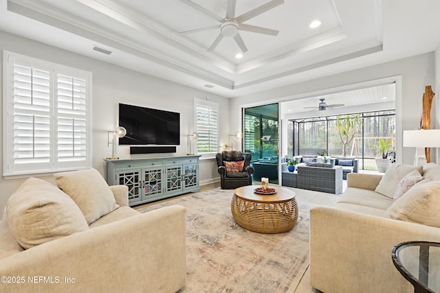 living area featuring ornamental molding, a ceiling fan, visible vents, and a healthy amount of sunlight