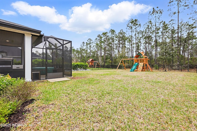 view of yard with glass enclosure, fence, and a playground