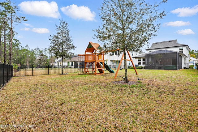 view of yard with a sunroom, fence, and a playground