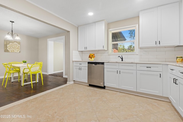 kitchen with dishwasher, light countertops, decorative backsplash, white cabinetry, and a sink