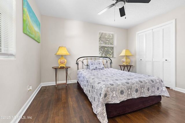 bedroom with a closet, a ceiling fan, baseboards, and dark wood-style flooring