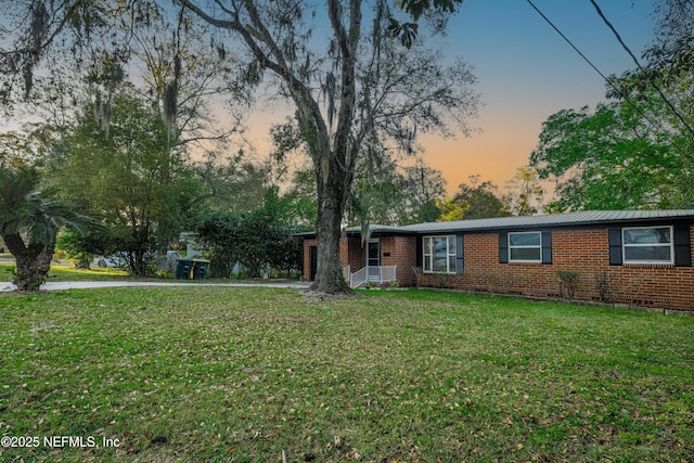 ranch-style house with brick siding and a yard