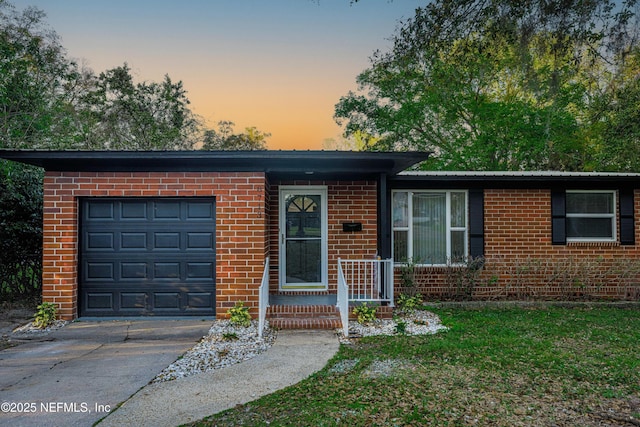 ranch-style house featuring a garage, brick siding, and driveway