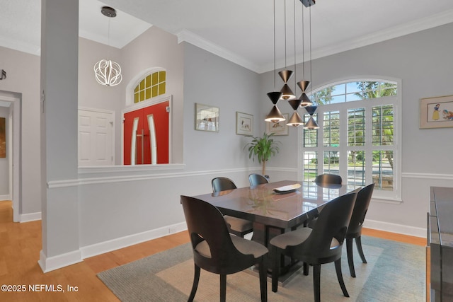 dining space featuring ornamental molding, wood finished floors, baseboards, and a chandelier