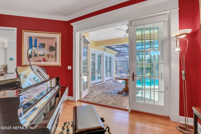 entryway with a healthy amount of sunlight, ornamental molding, and wood finished floors