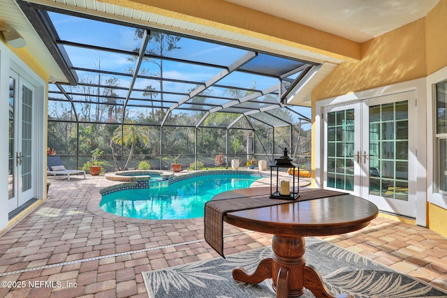 view of pool featuring french doors, a pool with connected hot tub, glass enclosure, and a patio area