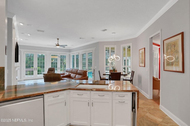 kitchen featuring dishwashing machine, french doors, white cabinetry, crown molding, and open floor plan