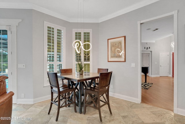 dining area with crown molding and baseboards