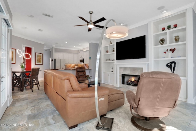 living area with a fireplace with flush hearth, visible vents, built in shelves, and crown molding