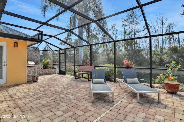 view of patio / terrace with grilling area and a lanai