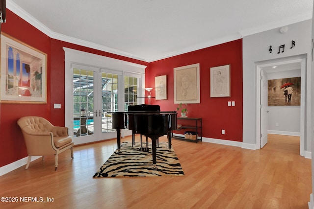 sitting room featuring light wood-type flooring, french doors, baseboards, and ornamental molding