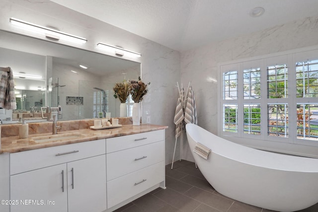 bathroom featuring a freestanding bath, a stall shower, vanity, and tile patterned flooring