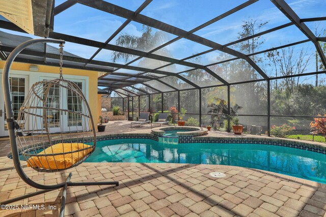 view of swimming pool with french doors, a patio, a lanai, and a pool with connected hot tub