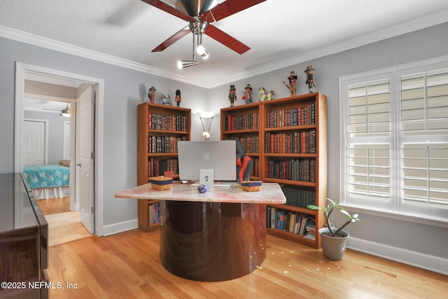 office space with ceiling fan, baseboards, light wood-style flooring, and ornamental molding