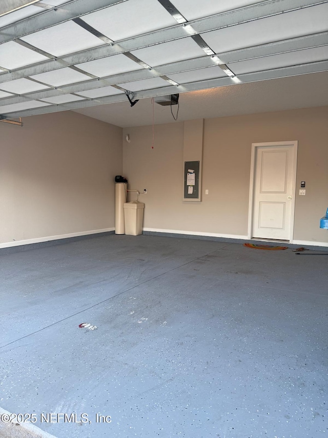 garage with electric panel, a garage door opener, and baseboards