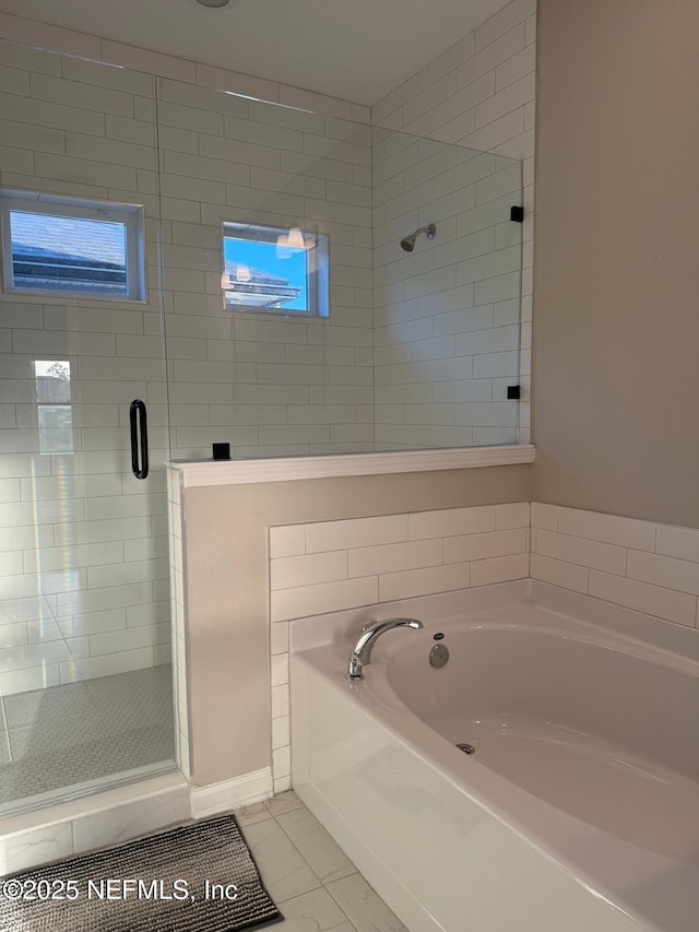 full bath featuring a garden tub, a shower stall, and tile patterned flooring