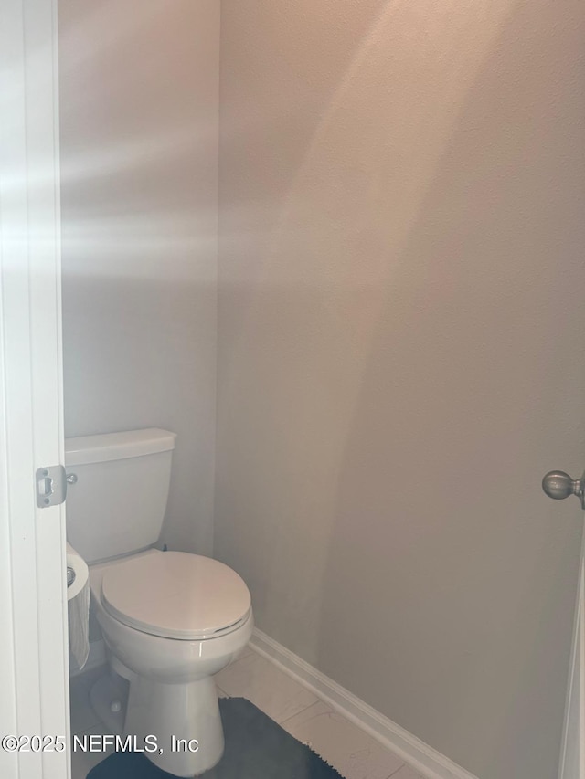 bathroom featuring tile patterned floors, baseboards, and toilet