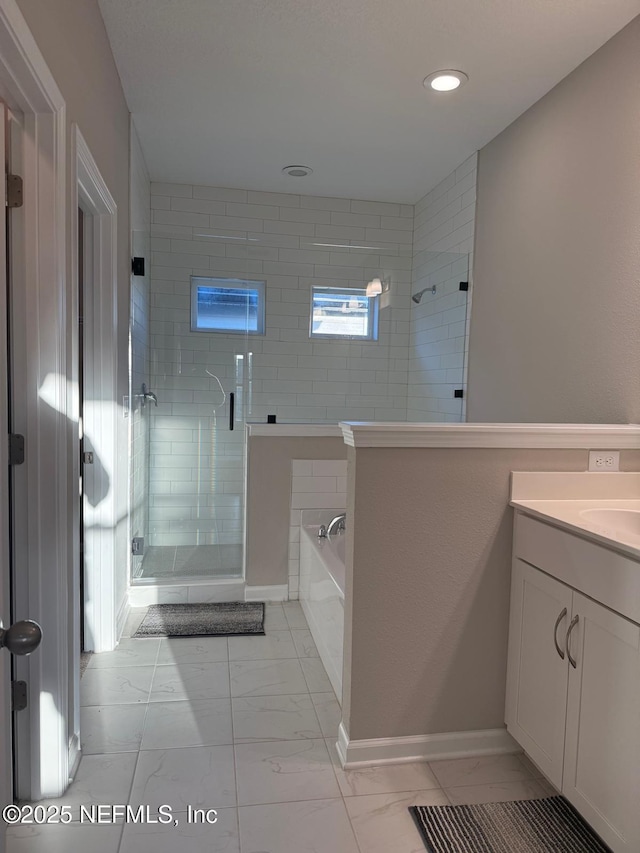 bathroom with a shower stall, baseboards, a bath, marble finish floor, and vanity