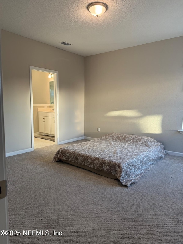 unfurnished bedroom with carpet flooring, baseboards, visible vents, and a textured ceiling