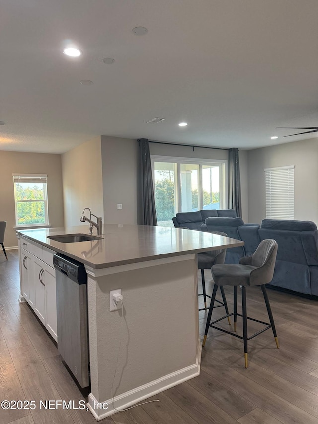 kitchen with a sink, stainless steel dishwasher, open floor plan, and a center island with sink