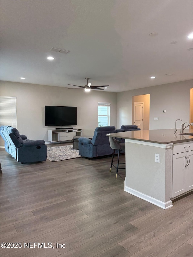 living room with visible vents, recessed lighting, ceiling fan, and wood finished floors