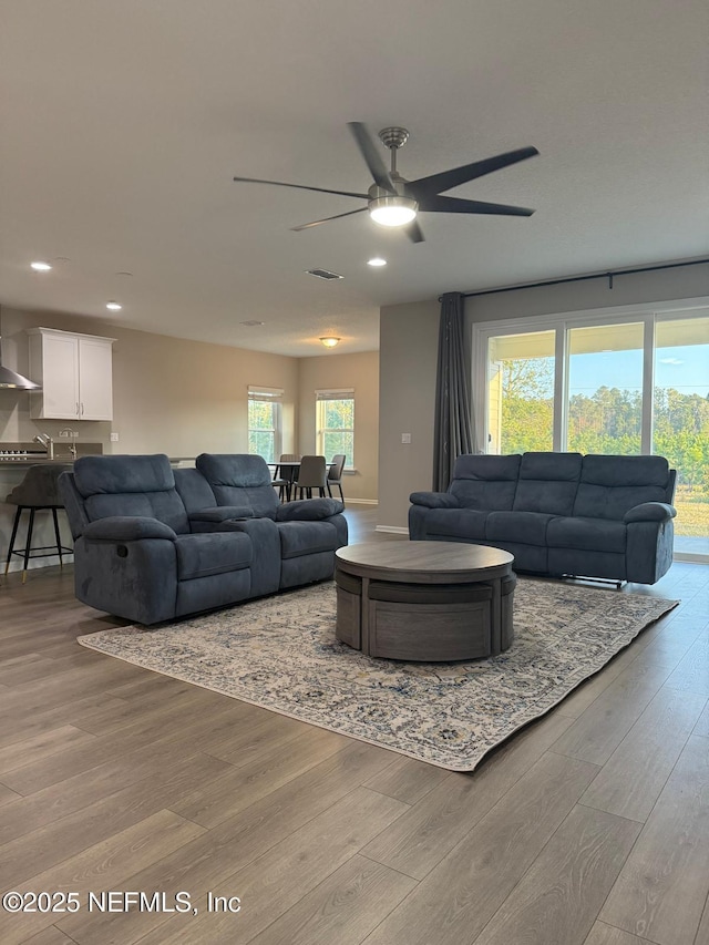 living room with recessed lighting, visible vents, wood finished floors, and a ceiling fan