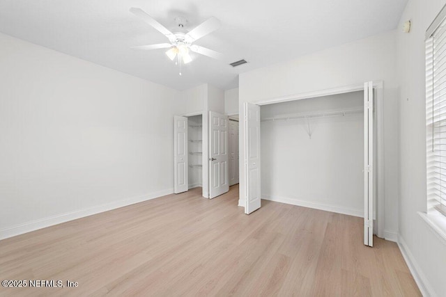 unfurnished bedroom with visible vents, baseboards, multiple closets, light wood-style flooring, and a ceiling fan