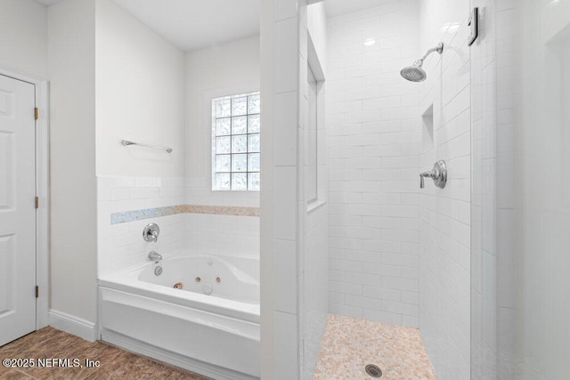 bathroom featuring a shower stall, wood finished floors, baseboards, and a whirlpool tub