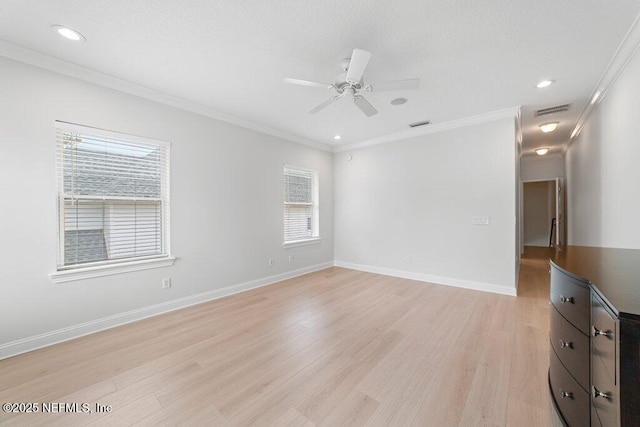 spare room with visible vents, crown molding, and light wood-type flooring