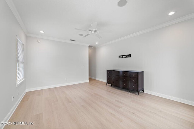 unfurnished room featuring a ceiling fan, visible vents, wood finished floors, baseboards, and crown molding