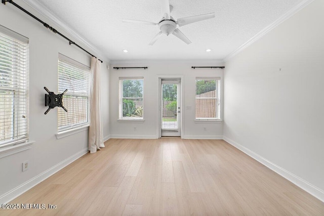 unfurnished room featuring baseboards, a textured ceiling, light wood-style flooring, and crown molding