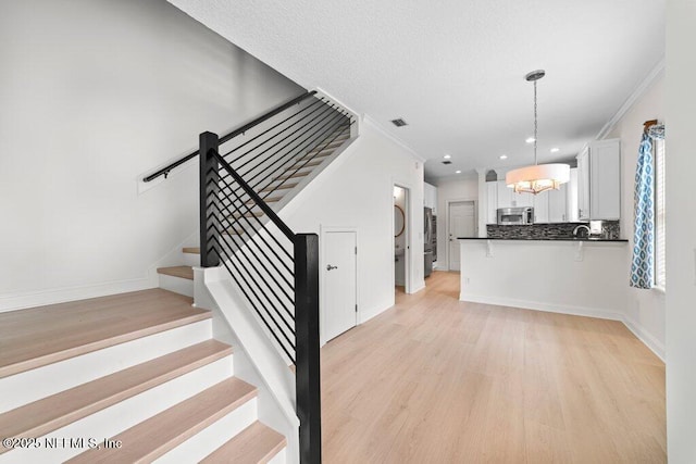 stairway with recessed lighting, baseboards, wood finished floors, and crown molding