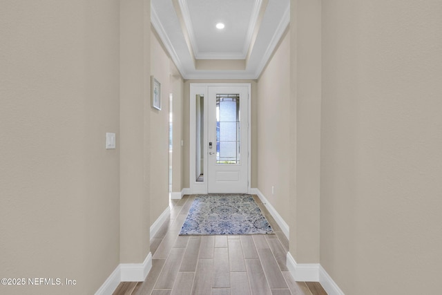 doorway featuring crown molding, baseboards, and wood tiled floor