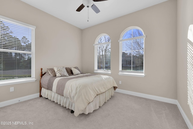 bedroom with light colored carpet, baseboards, and ceiling fan