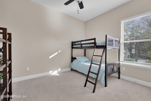 bedroom featuring baseboards, multiple windows, and carpet