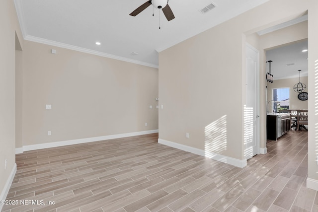 unfurnished room featuring visible vents, ceiling fan, baseboards, wood finish floors, and ornamental molding