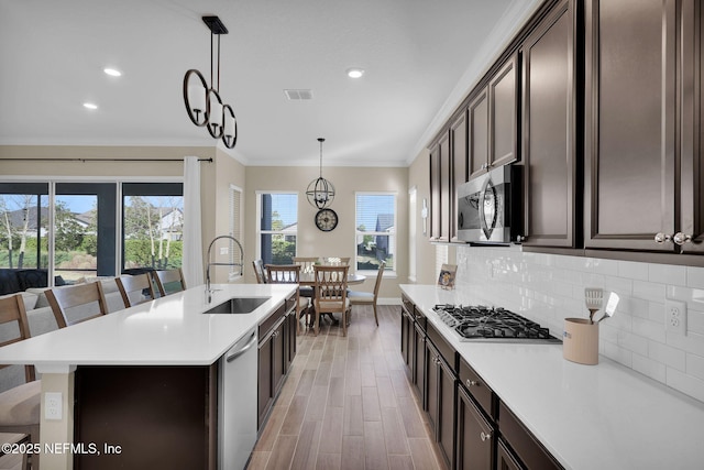 kitchen with a sink, decorative backsplash, light countertops, and stainless steel appliances