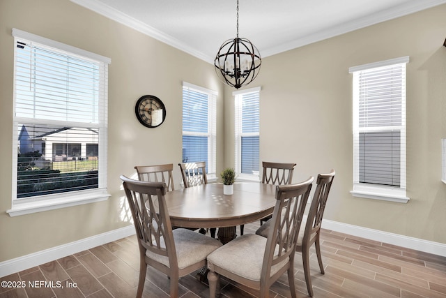 dining room with baseboards, a healthy amount of sunlight, wood tiled floor, and crown molding