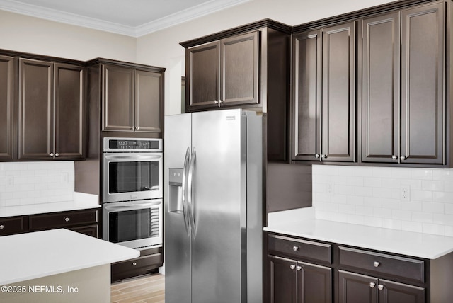 kitchen featuring dark brown cabinets, stainless steel appliances, light countertops, and ornamental molding