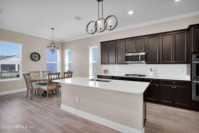 kitchen with a sink, plenty of natural light, backsplash, and stainless steel appliances