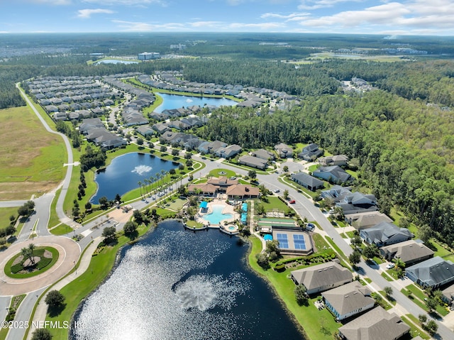 drone / aerial view featuring a residential view, a water view, and a wooded view