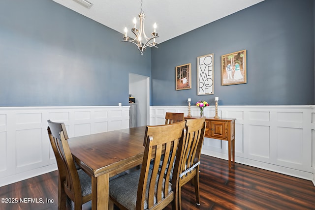 dining area featuring a chandelier, dark wood finished floors, and wainscoting