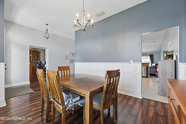 dining area with visible vents, an inviting chandelier, and wood finished floors