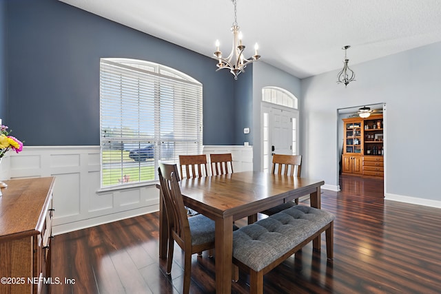 dining room featuring dark wood-style floors, a decorative wall, an inviting chandelier, and a wainscoted wall