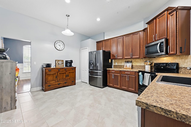 kitchen featuring tasteful backsplash, baseboards, hanging light fixtures, stainless steel appliances, and a sink